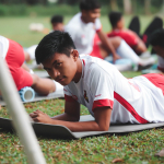 Anak muda berlatih olahraga tim, menunjukkan disiplin dan fokus