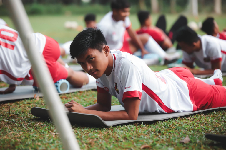 Anak muda berlatih olahraga tim, menunjukkan disiplin dan fokus